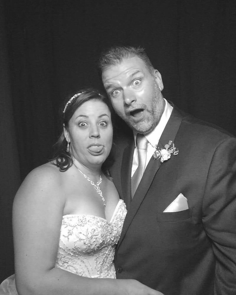 Michael and Jade at their wedding, pulling faces in the photobooth